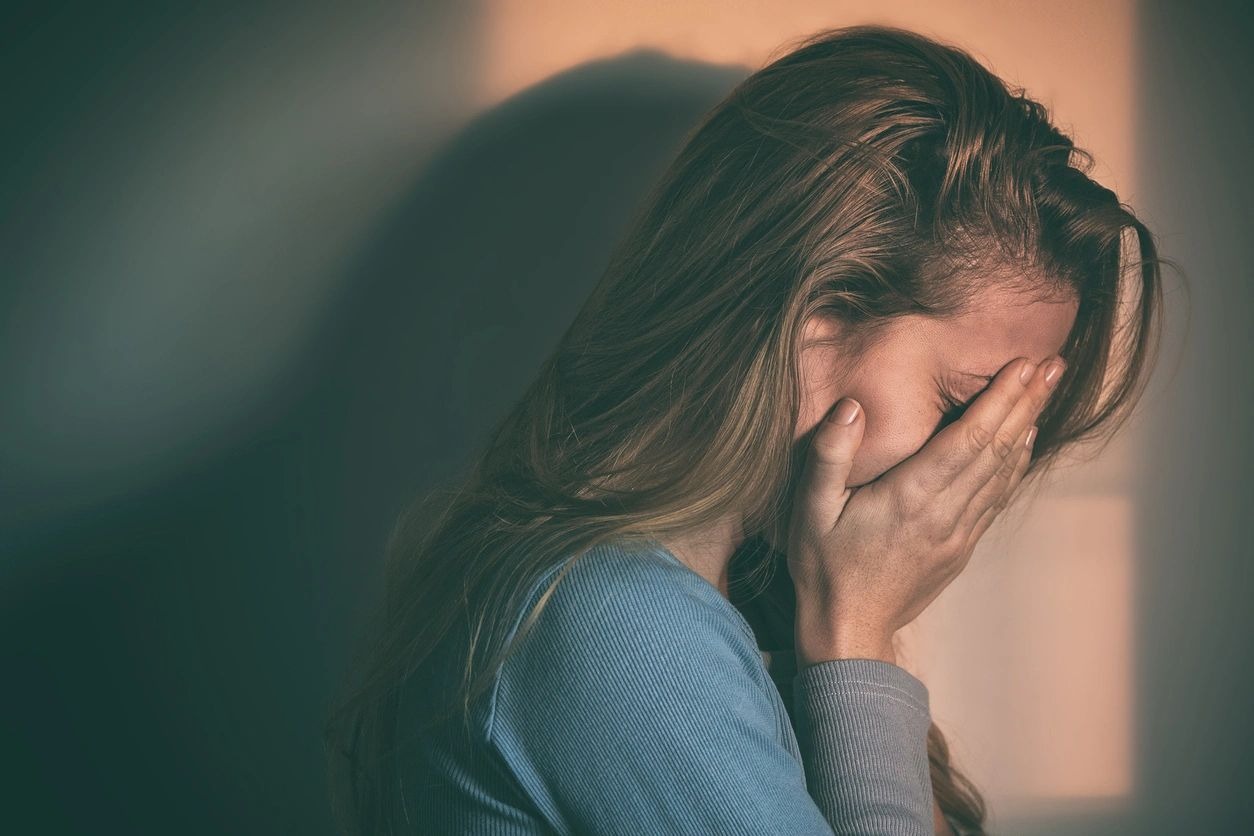 Sad woman sitting alone in an empty room