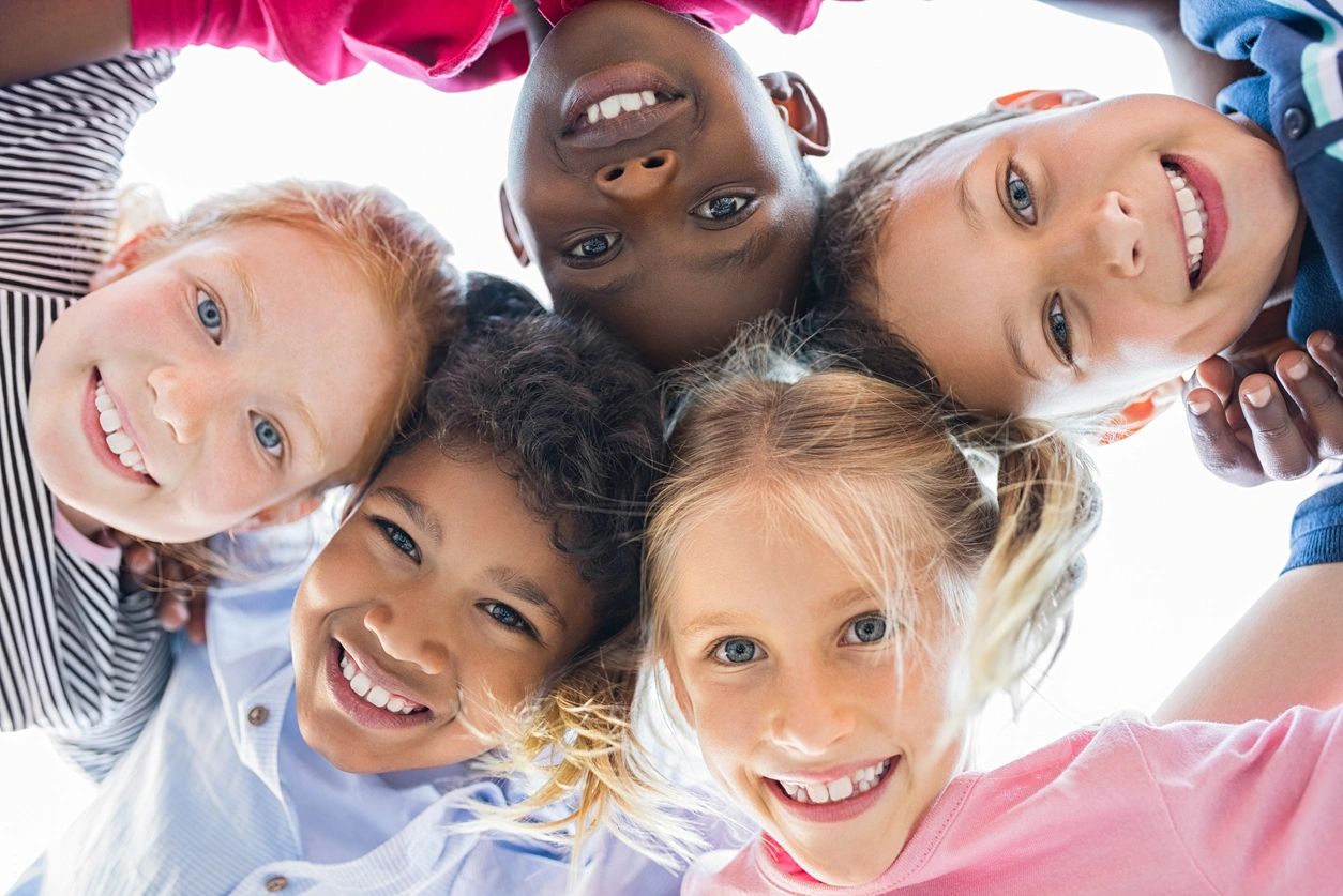 Smiling children forming a circle overhead.