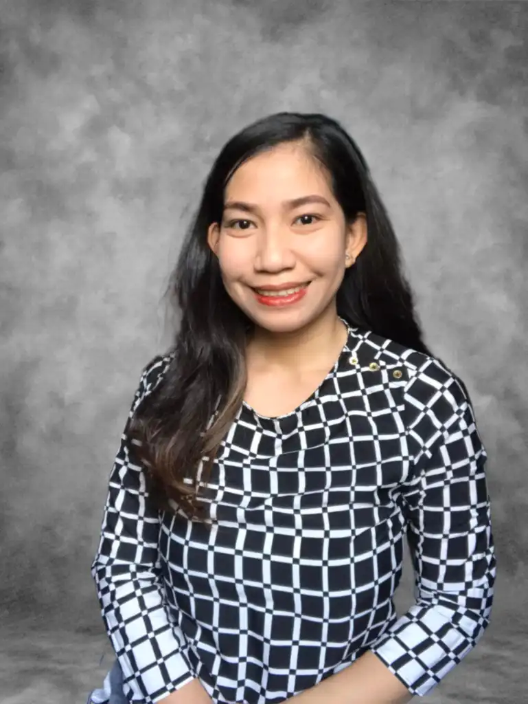 Smiling person in patterned black and white top.